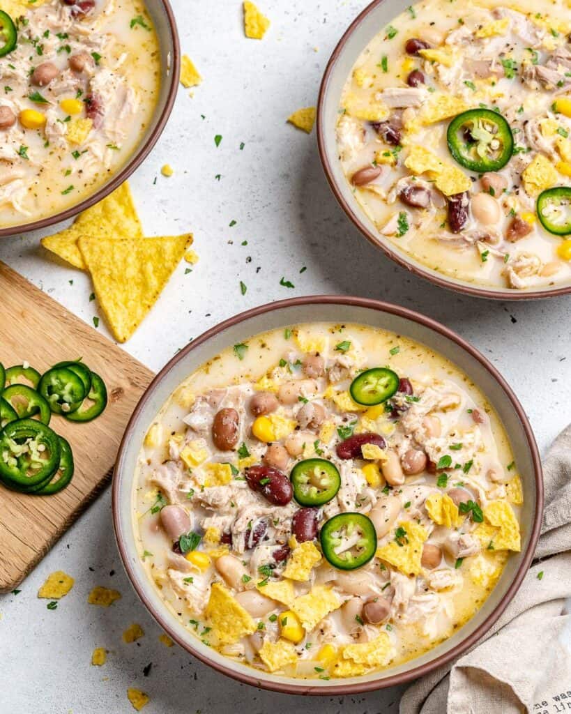 top view of white chicken chili in a bowl with another bowl full of chili next to it 