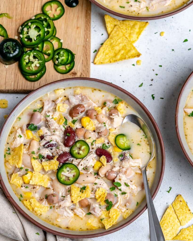 top view of a bowl of white chicken chili with spoon in bowl