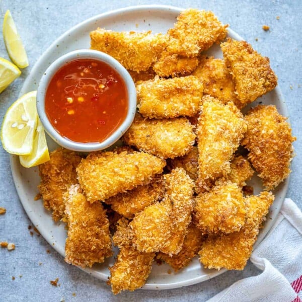 top view of chicken nuggets on a plate with red dipping sauce