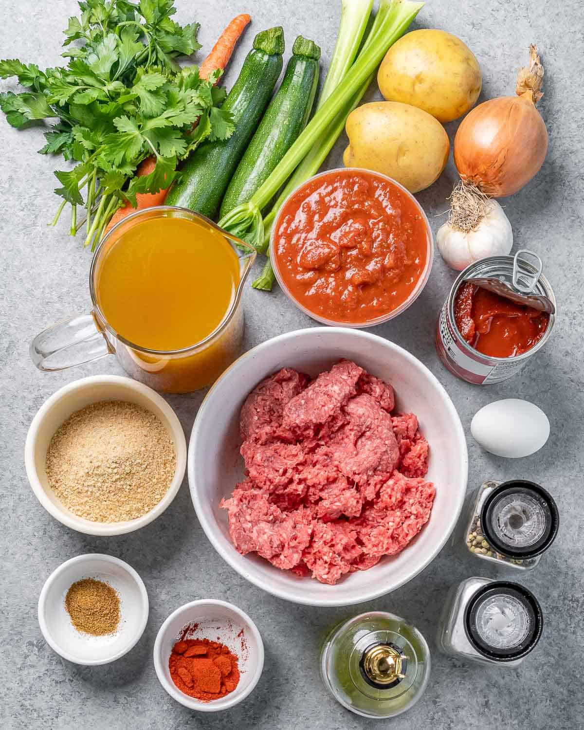 Raw beef, breadcrumbs, salsa, spices, herbs, potatoes and onion all divided into small portions.