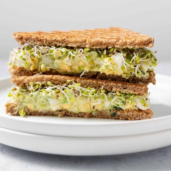 side shot of egg salad sandwich halves on a plate