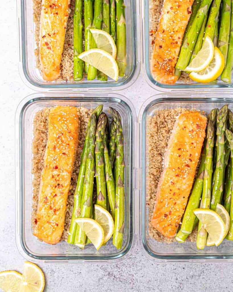 Glass bowls filled with honey salmon, asparagus and quinoa.