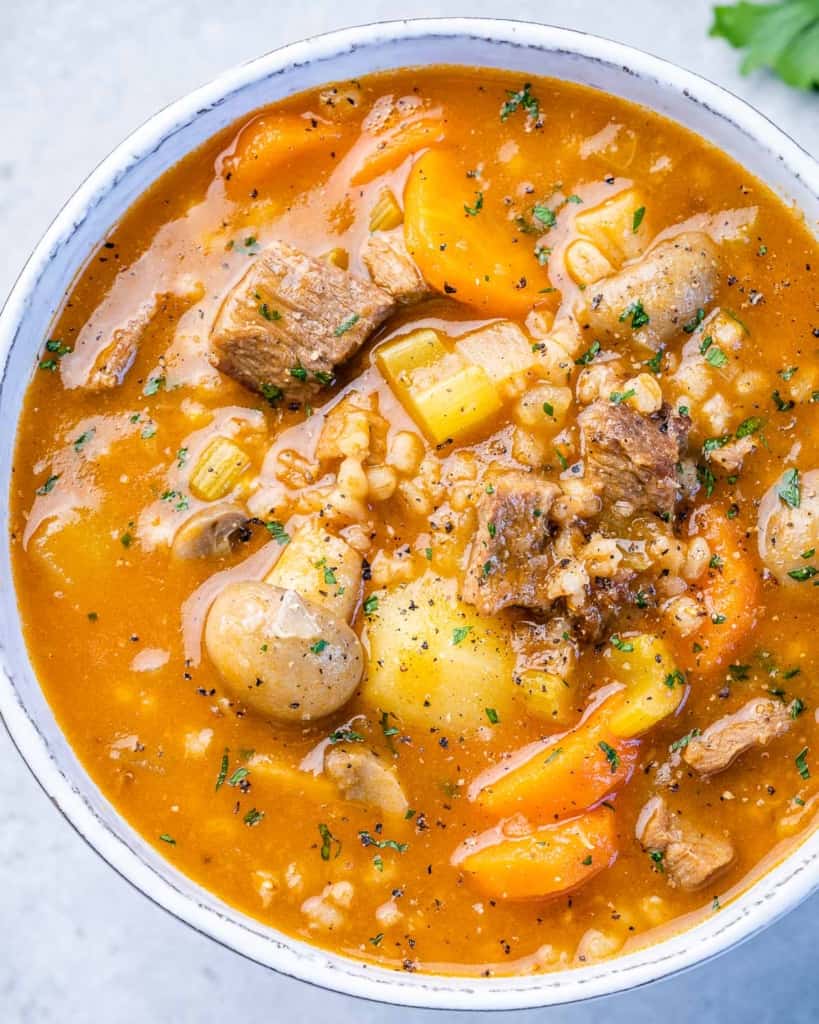 close up beef and barely soup in a white bowl