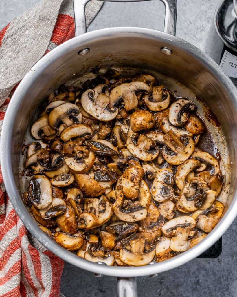 Mushrooms sautéing in a pot.