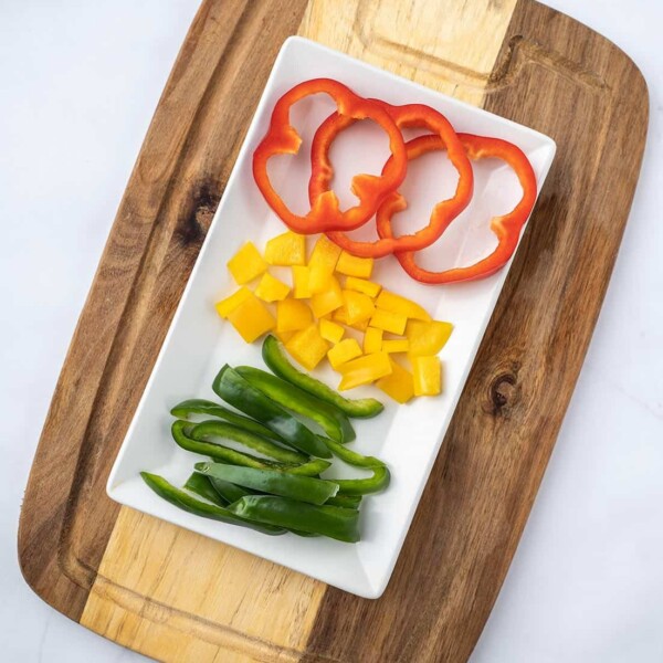 sliced bell peppers on white plate with cutting board