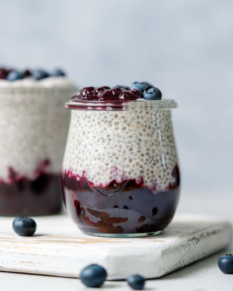 side shot of blueberry chia pudding in a jar topped with blueberries