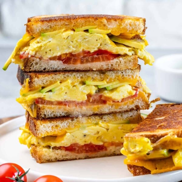 side shot of egg sandwich stacked over each other on a plate