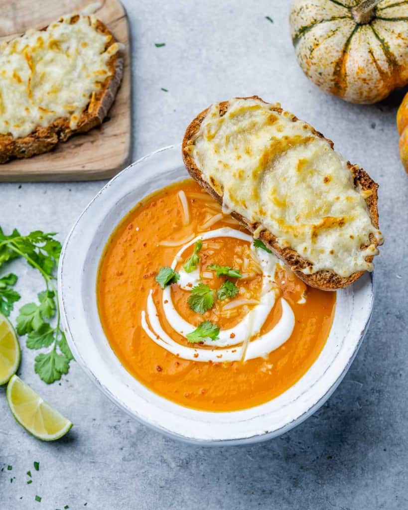 top view butternut squash soup in a white bowl topped with toast