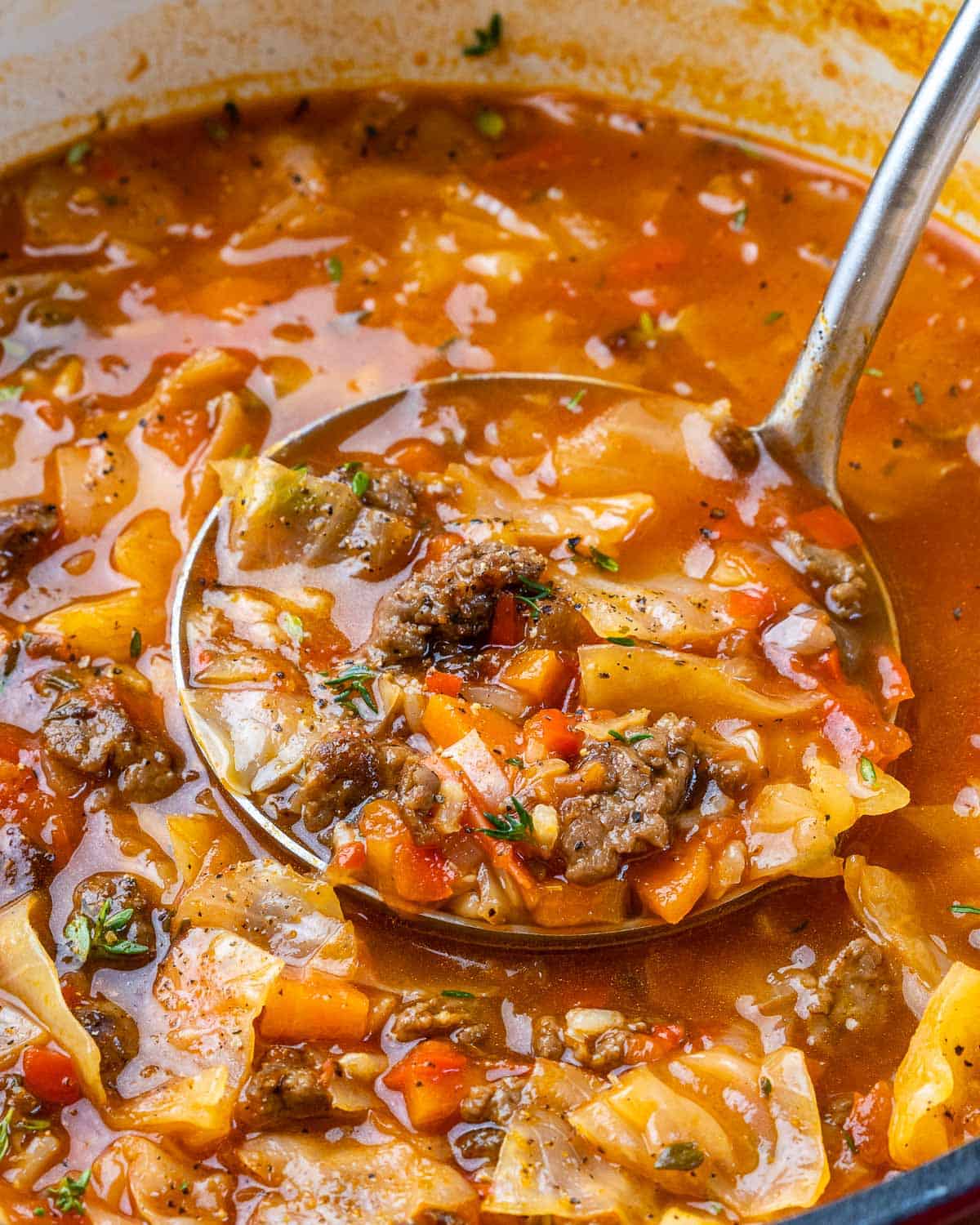 Close view of ladle filled with cabbage soup. 