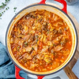 Top view of cabbage soup in a red pot.