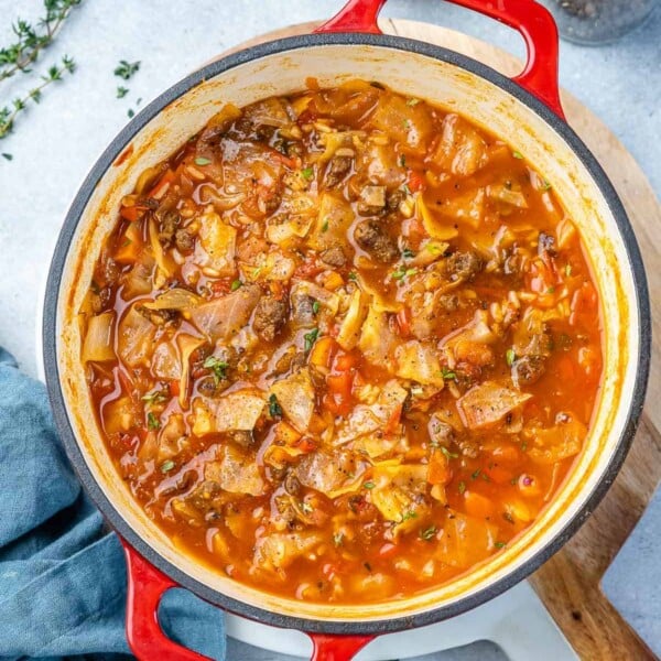 Top view of cabbage soup in a red pot.