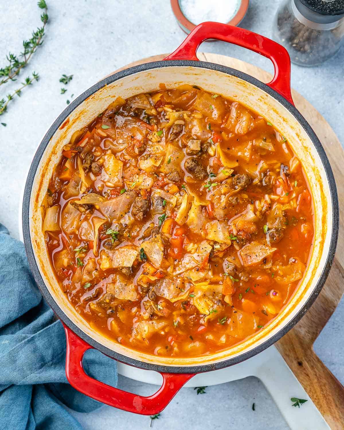 Top view of cabbage soup in a red pot.