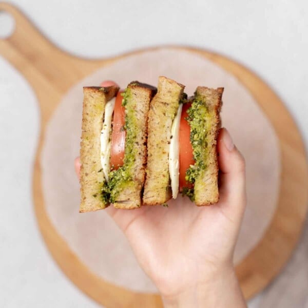 hand holding two caprese sandwich halves