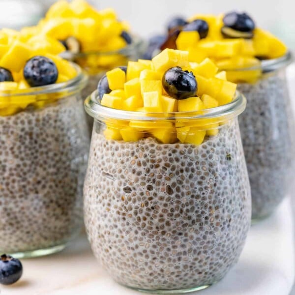 Chia pudding in a jar, topped with chopped mango and blueberry.