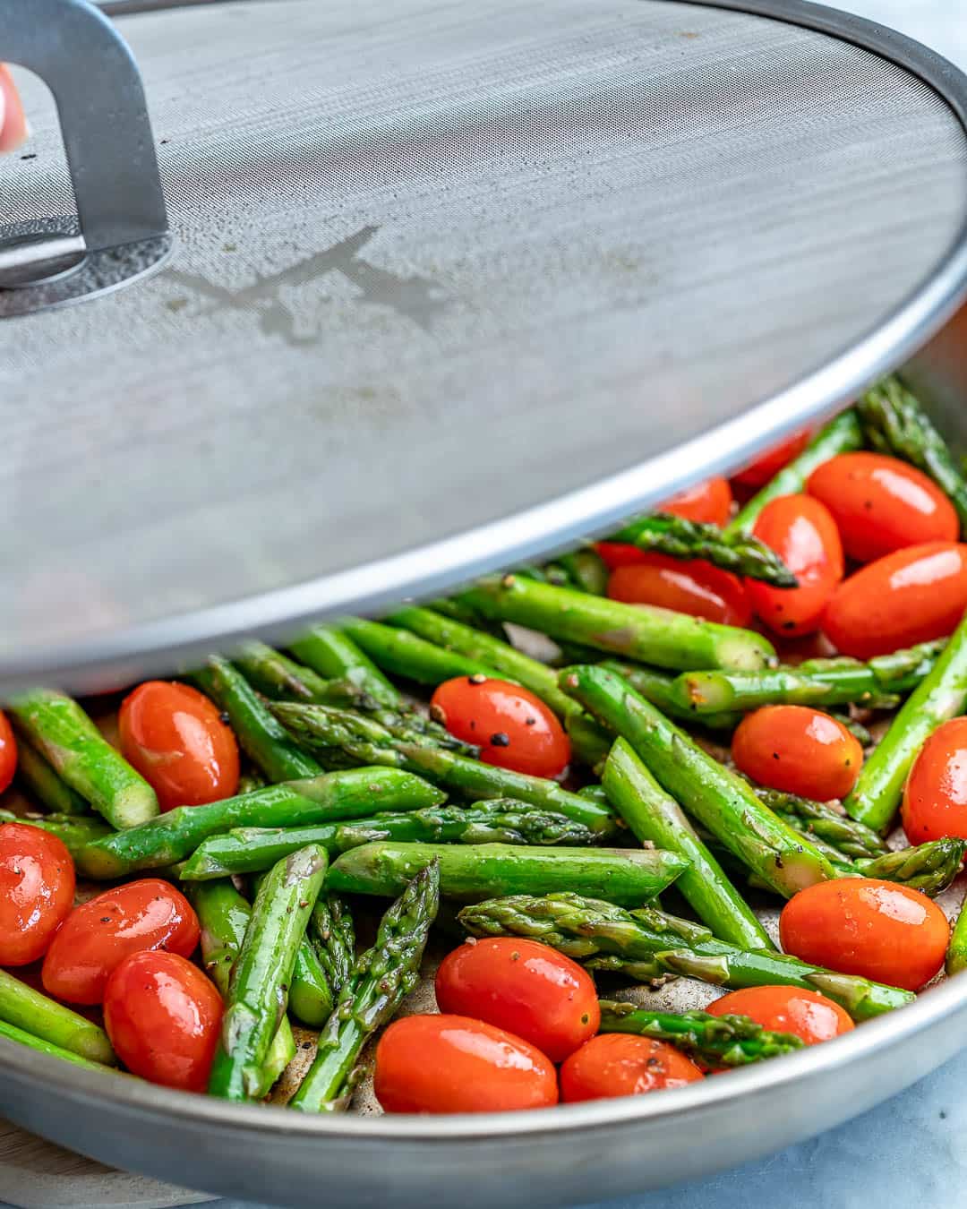 sauteed asparagus and cherry tomatoes in a pan