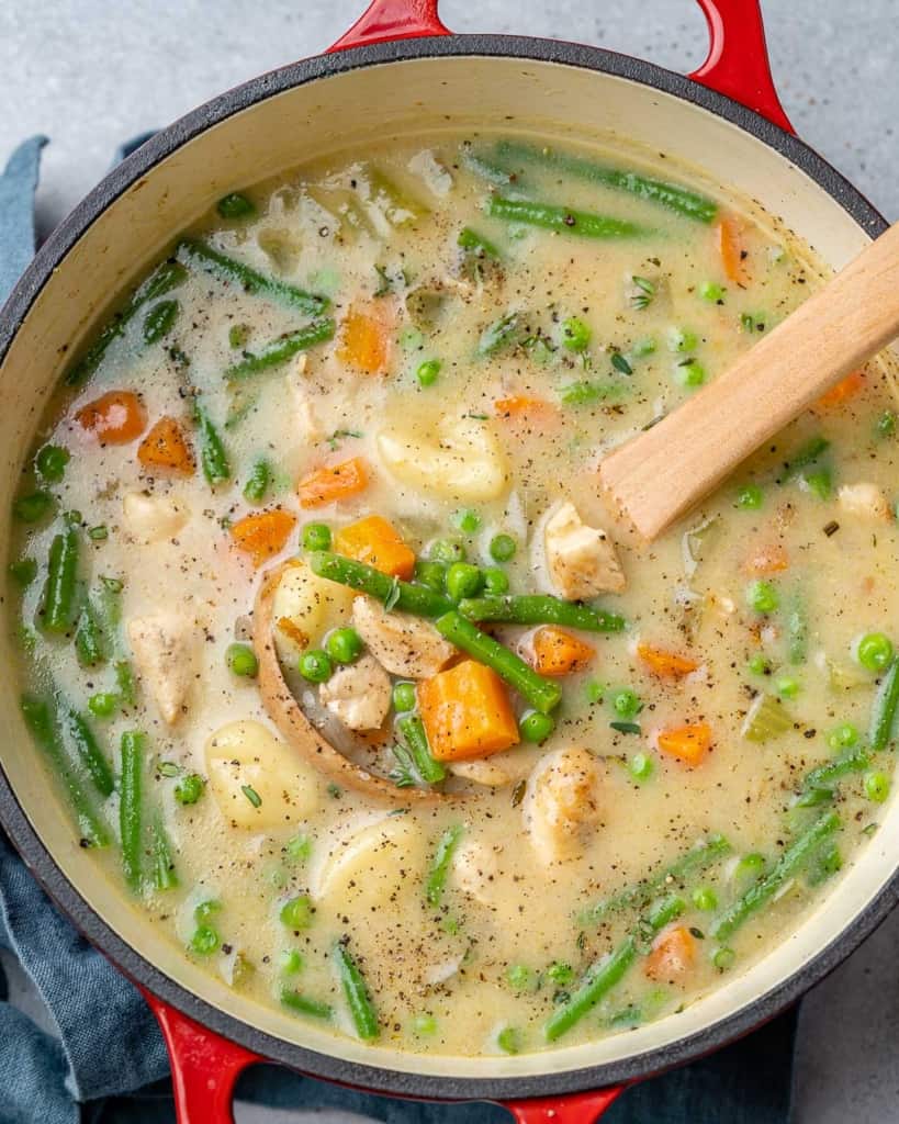 top view chicken and gnocchi soup in a red pot