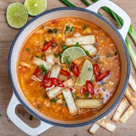 top view of a dutch oven that has chicken tortilla soup topped with tortilla