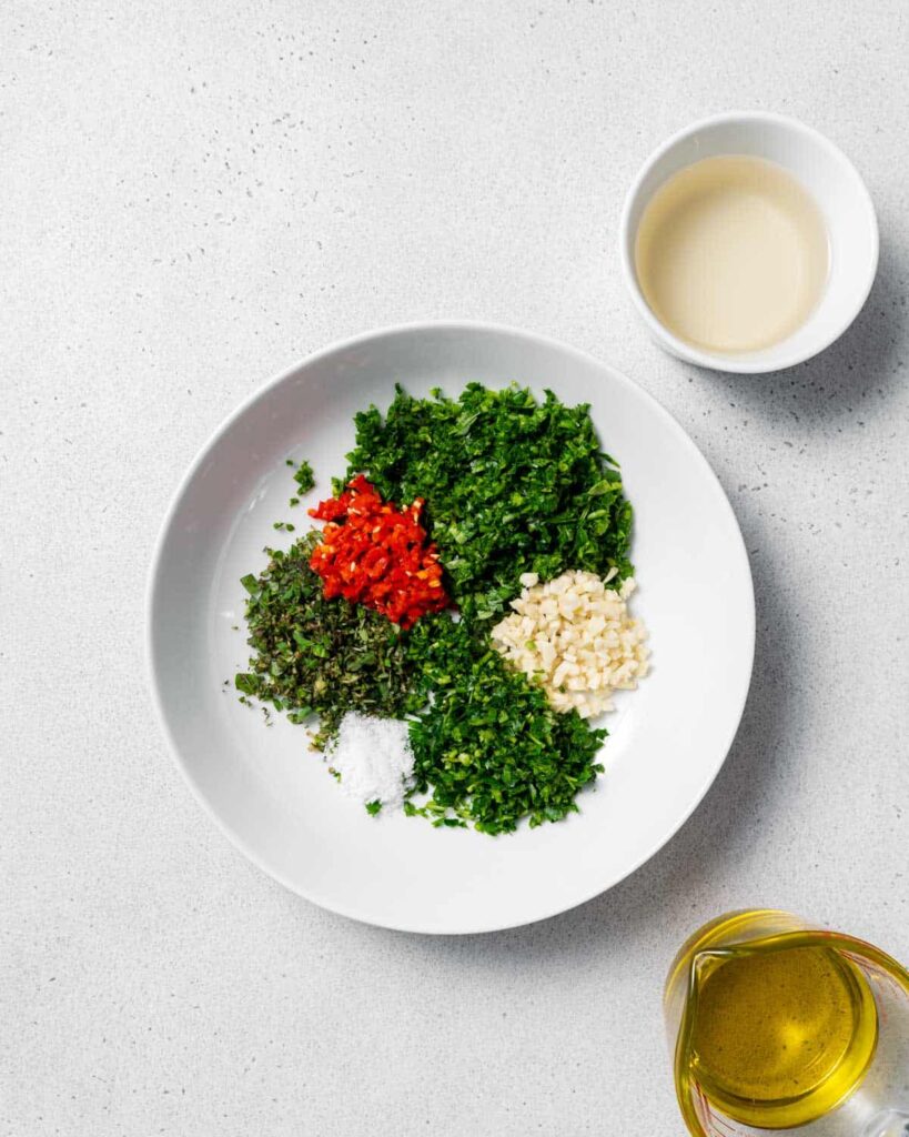 ingredients to make chimichurri in a bowl