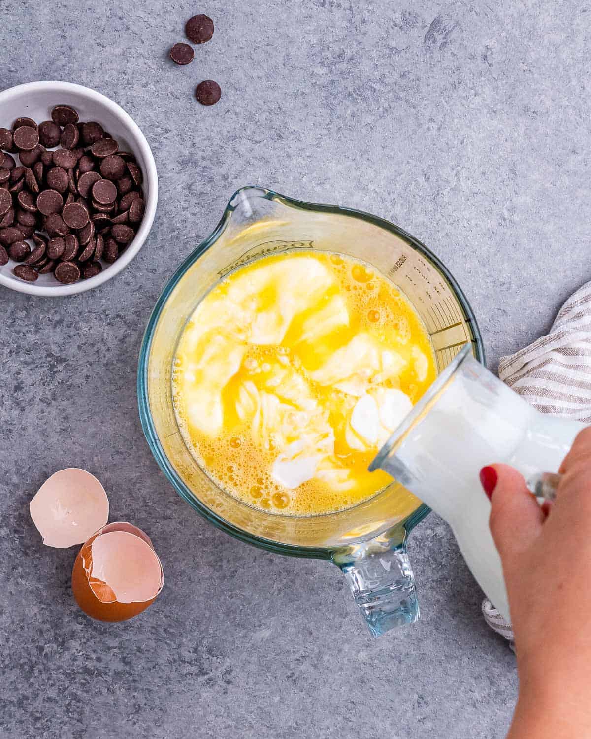 Pouring buttermilk into beaten eggs.