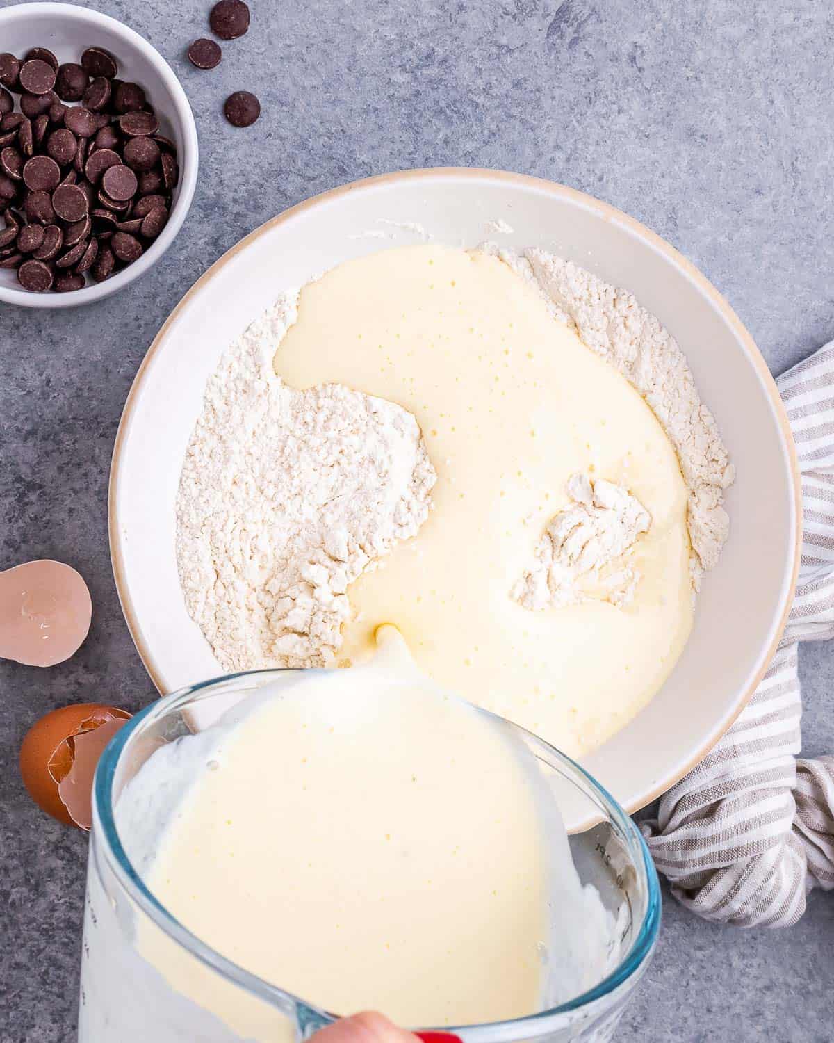 Pouring buttermilk mixture into flour mixture.