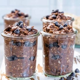 Four jars of chocolate overnight oats with chocolate chips.