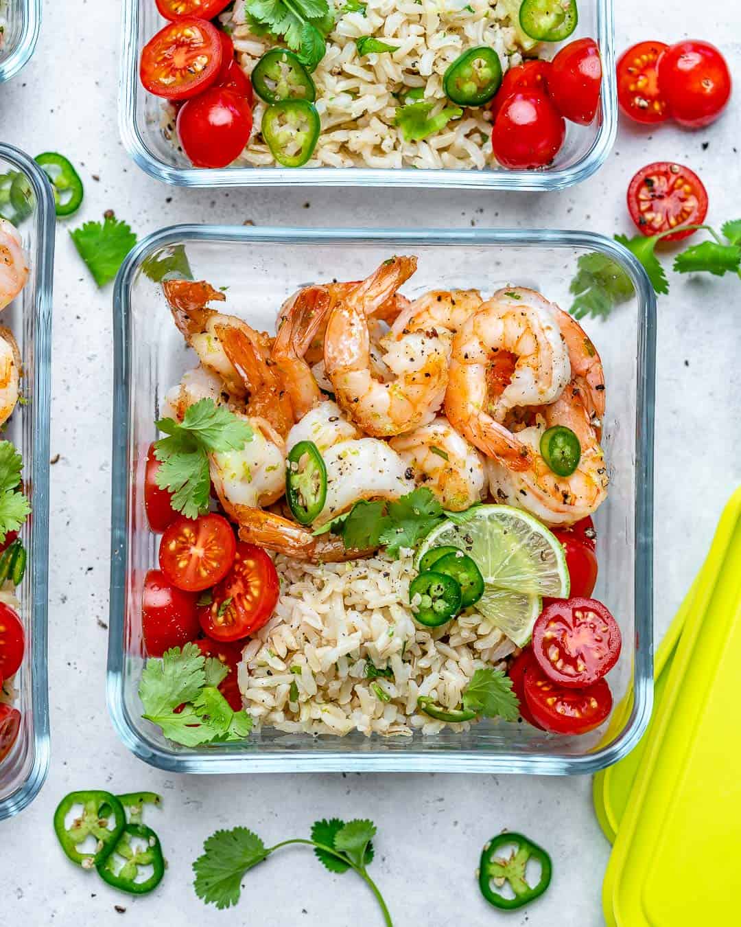 a meal prep bowl with sauteed shrimp and side of rice.