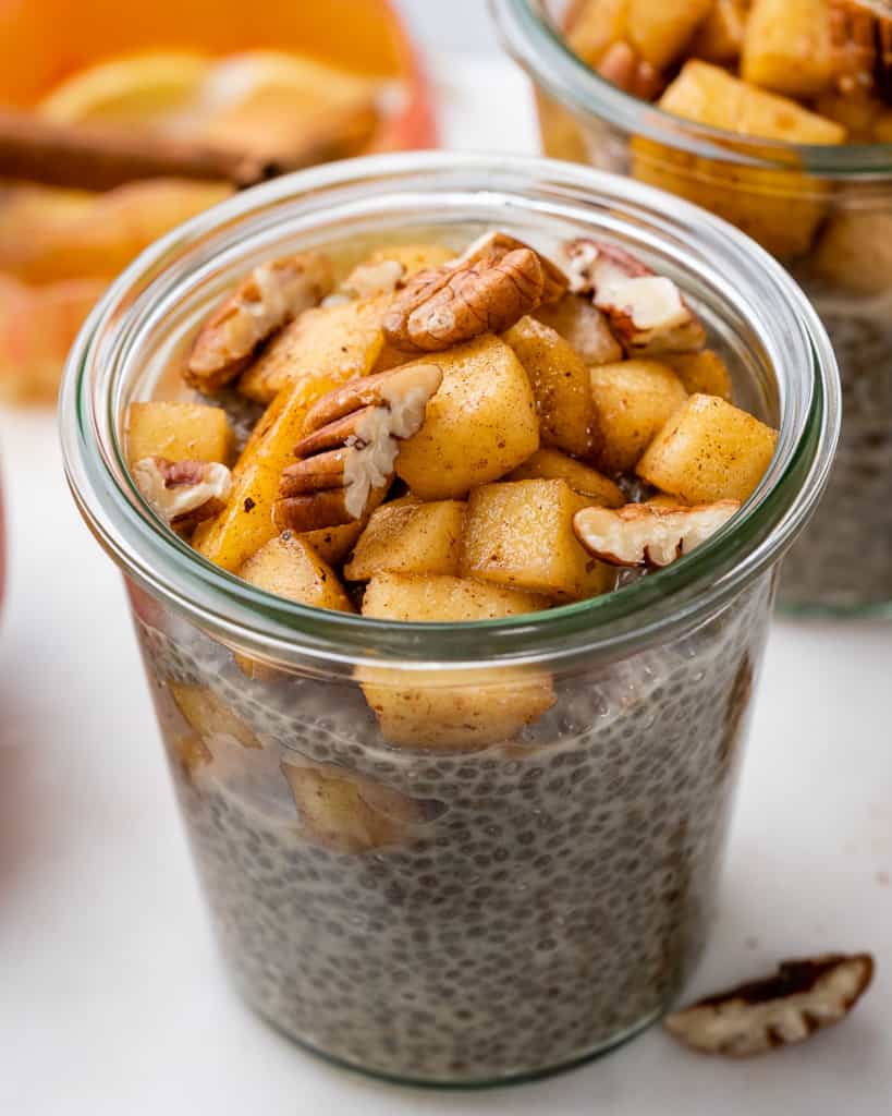 side shot of chia pudding in a jar topped with apple pie mix