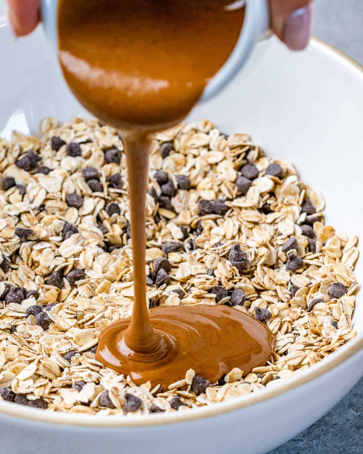 Pouring almond butter into oat mixture.