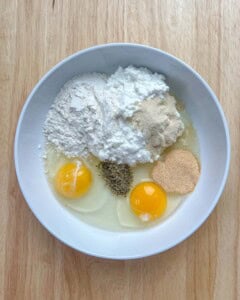 cottage cheese, flour, eggs, seasonings, in a white bowl.