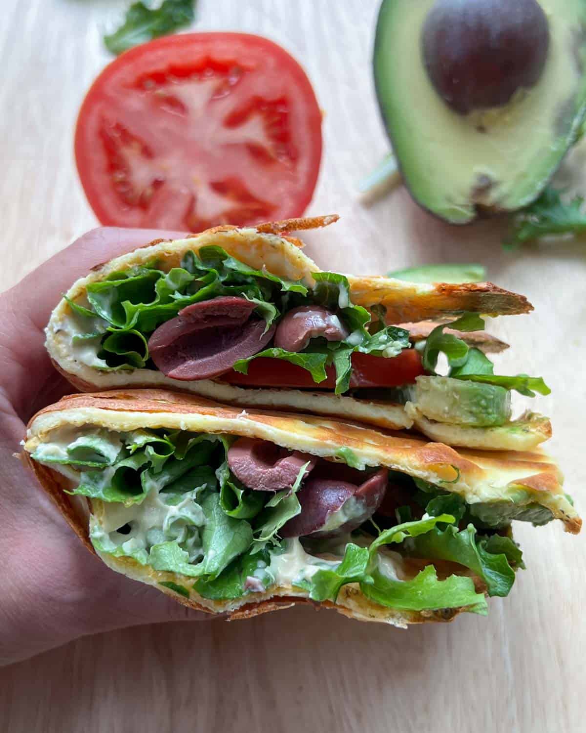 hand holding two halves of cottage cheese wrap.