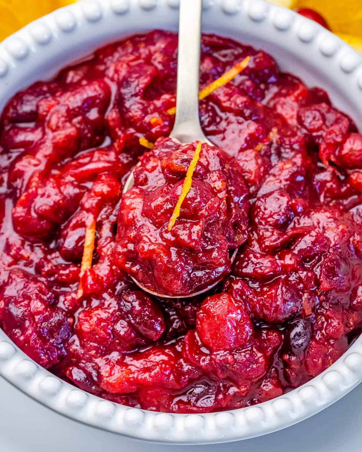 A spoon in a bowl of cranberry orange sauce.