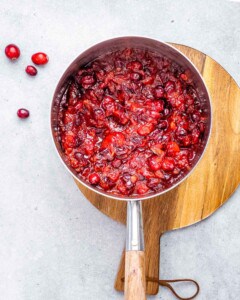 Cranberry orange sauce cooking in a saucepan.