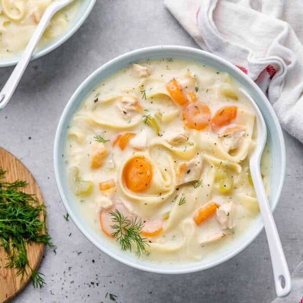 top view noodle soup in a white bowl with spoon in it