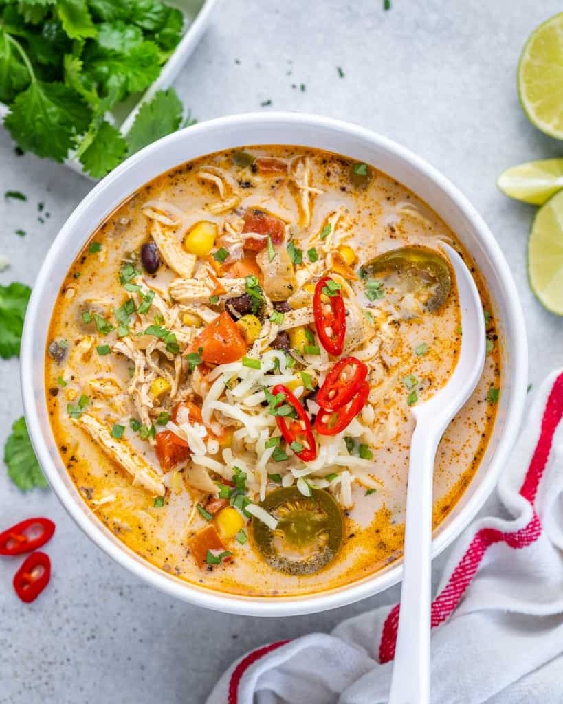 top view tortilla soup in a white bowl with white spoon in it.