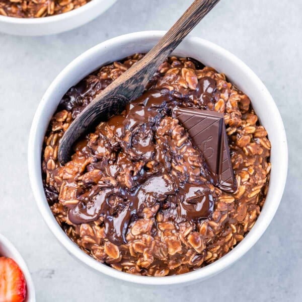 top view of a white bowl with chocolate cooked oatmeal topped with melted dark chocolate
