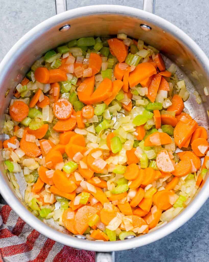 Veggies sautéing in a pot.