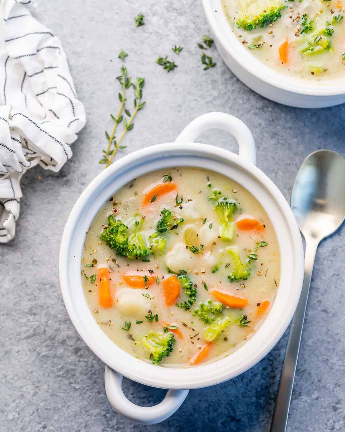 Top view of a white round bowl of creamy vegetable soup.