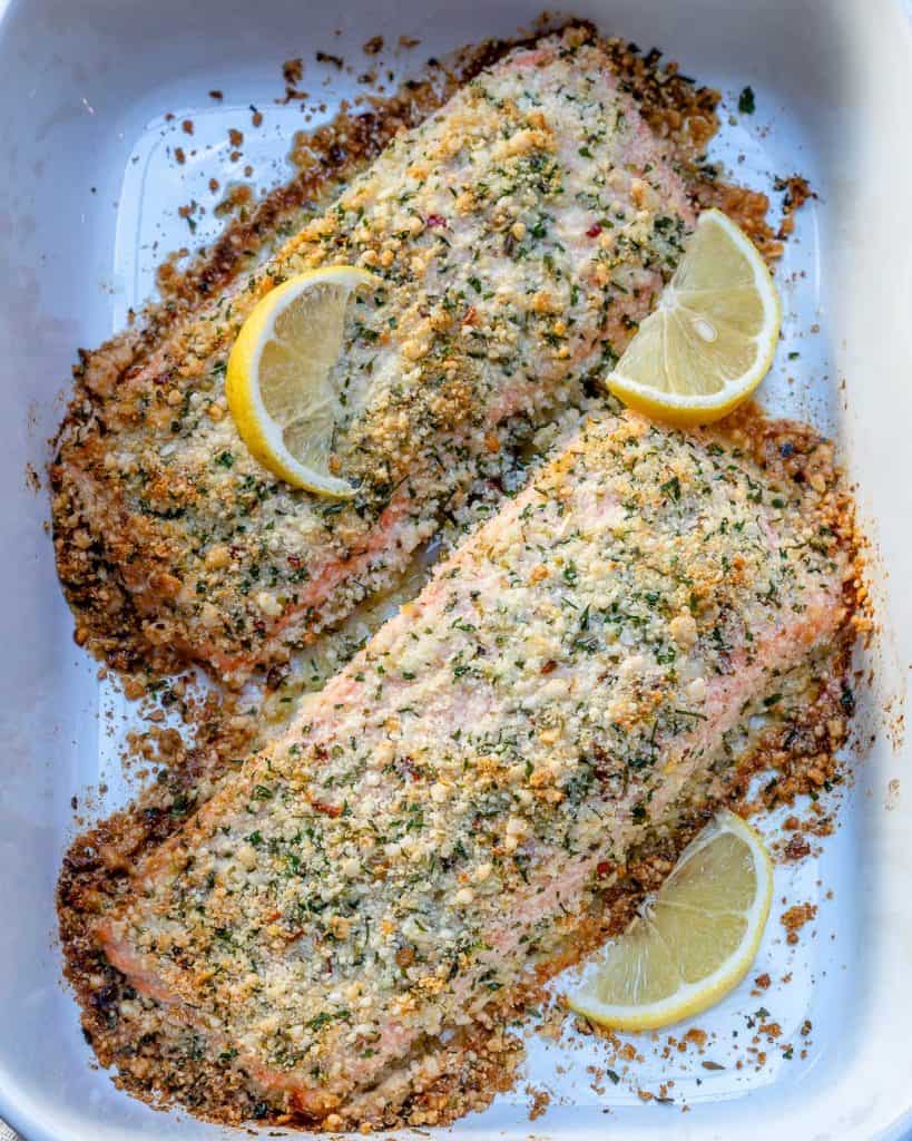 top view of 2 crispy baked salmon a white dish with lemon garnishes