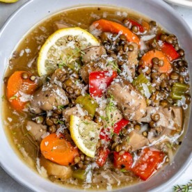 top view of crockpot lentil soup with mushrooms and carrots with lemon garnish