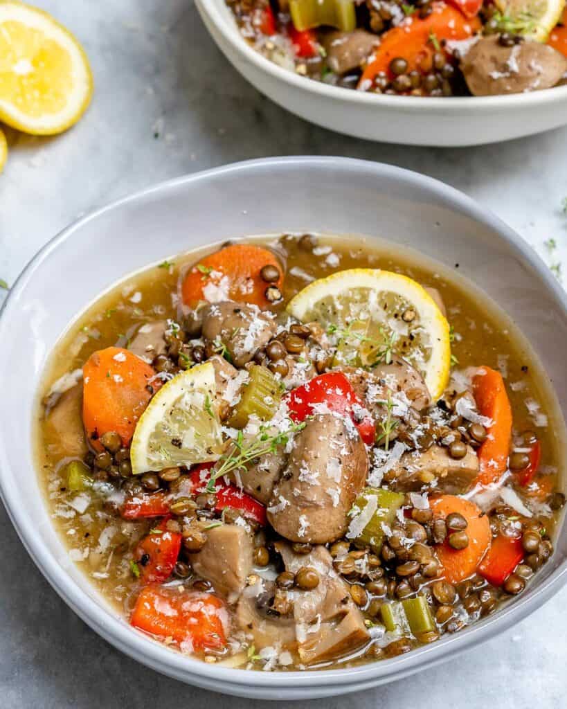 side shot of a bowl of lentil and mushroom soup with carrots 