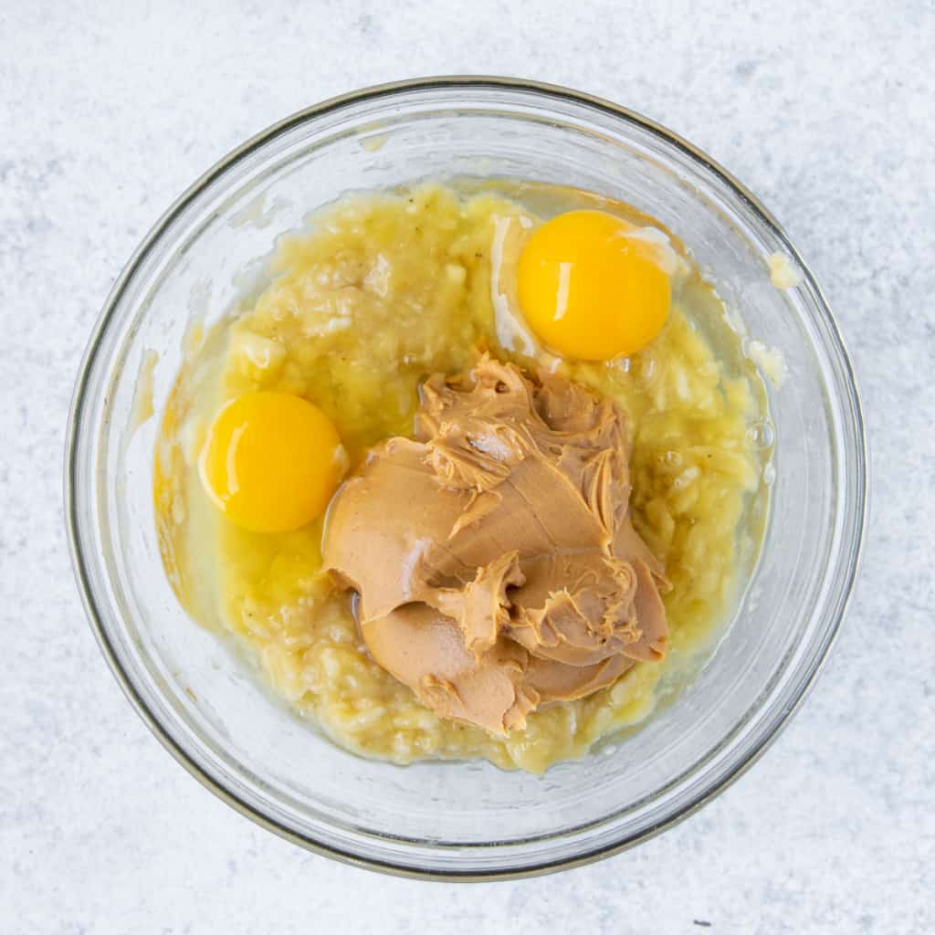mashed banana, eggs, peanut butter in a bowl