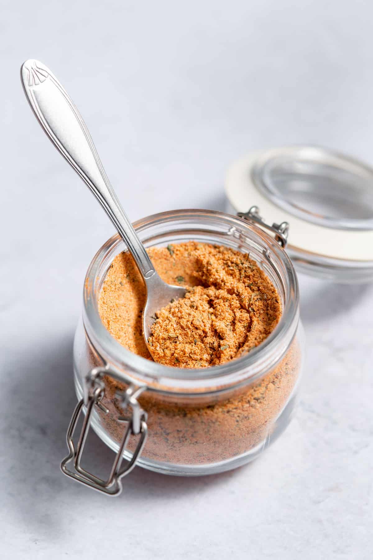 How To Make Cajun Seasoning side shot of cajun seasoning in a jar with spoon in it