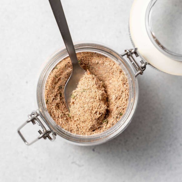 top view of jerk seasoning in a jar with spoon in it
