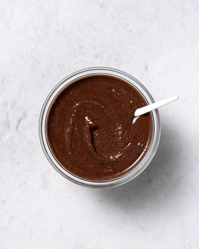 top view of homemade Nutella in a jar with spoon in jar