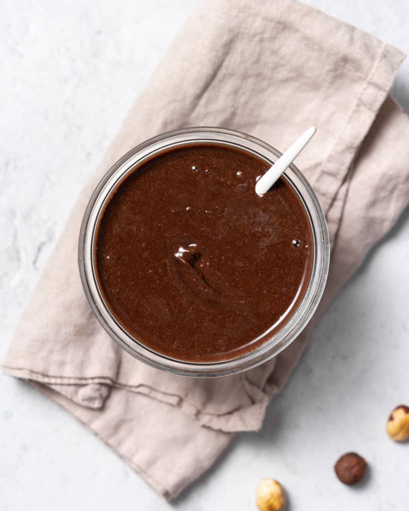 top view of a jar of homemade Nutella with spoon in jar