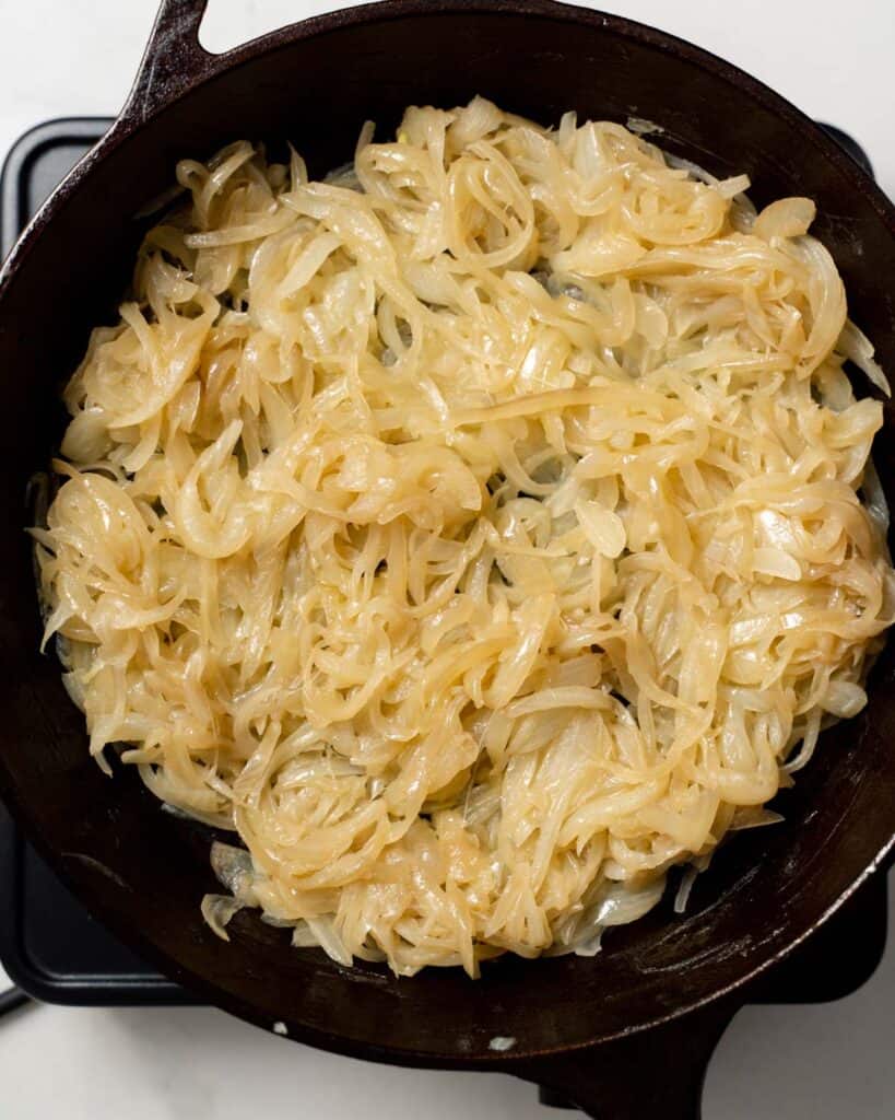 onions starting to turn brown in a black skillet