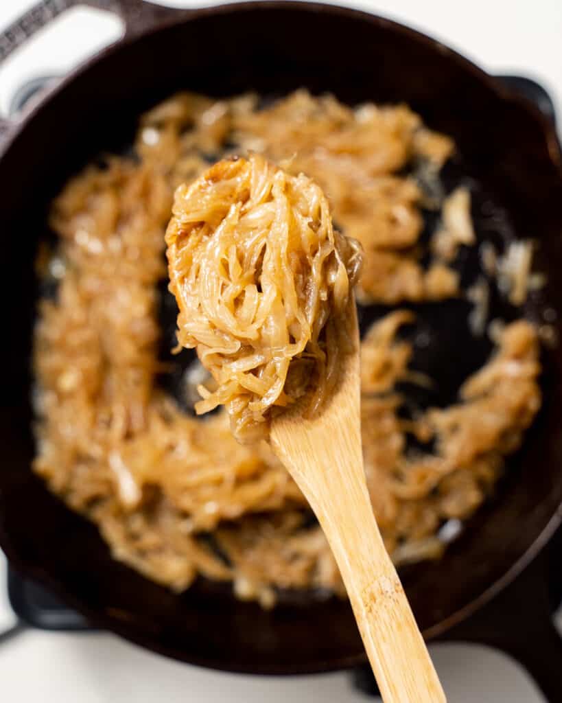 wooden spoon holding some caramelized onions
