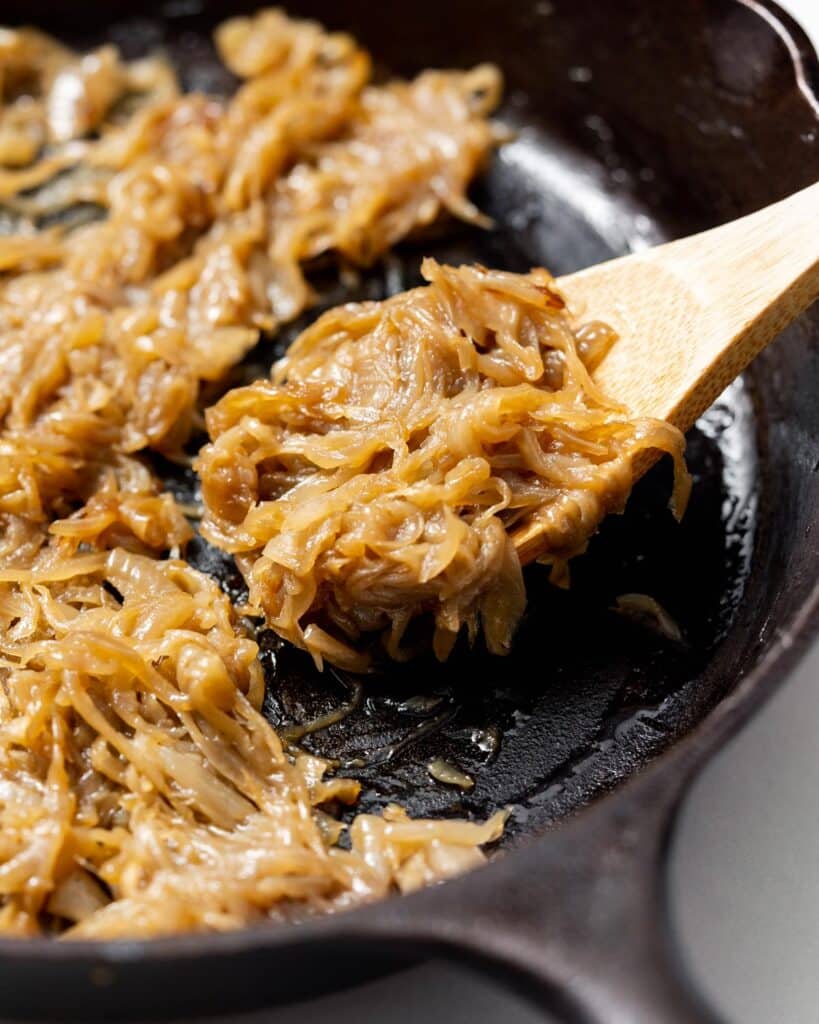 spoonful of caramelized onions in a black skillet