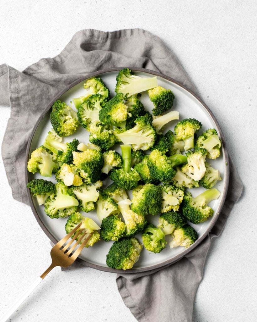 Broccoli served on a plate with a fork.