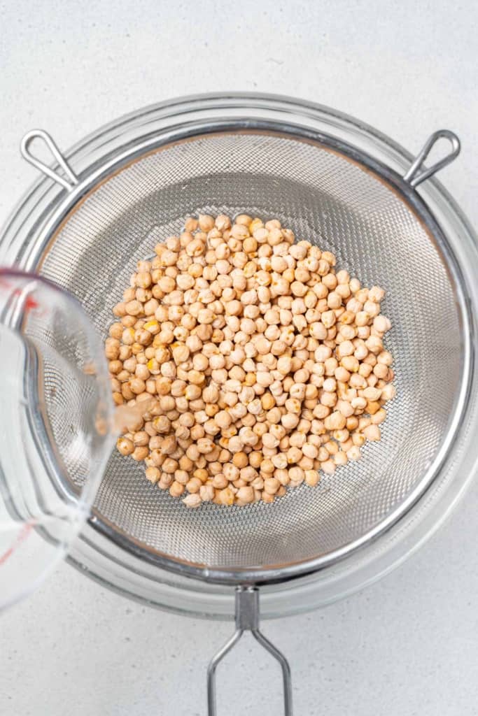Rinsing chickpeas in a strainer.